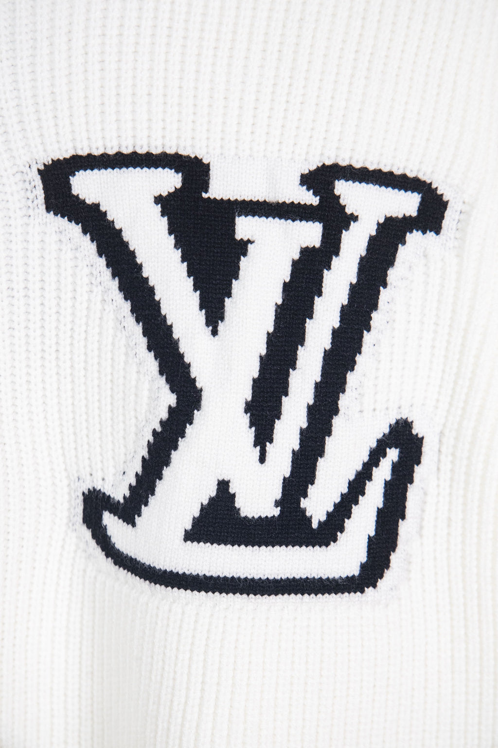 White knit sweater with oversized navy LV logo close-up