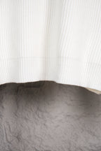 White ribbed knit sweater hem with curved bottom