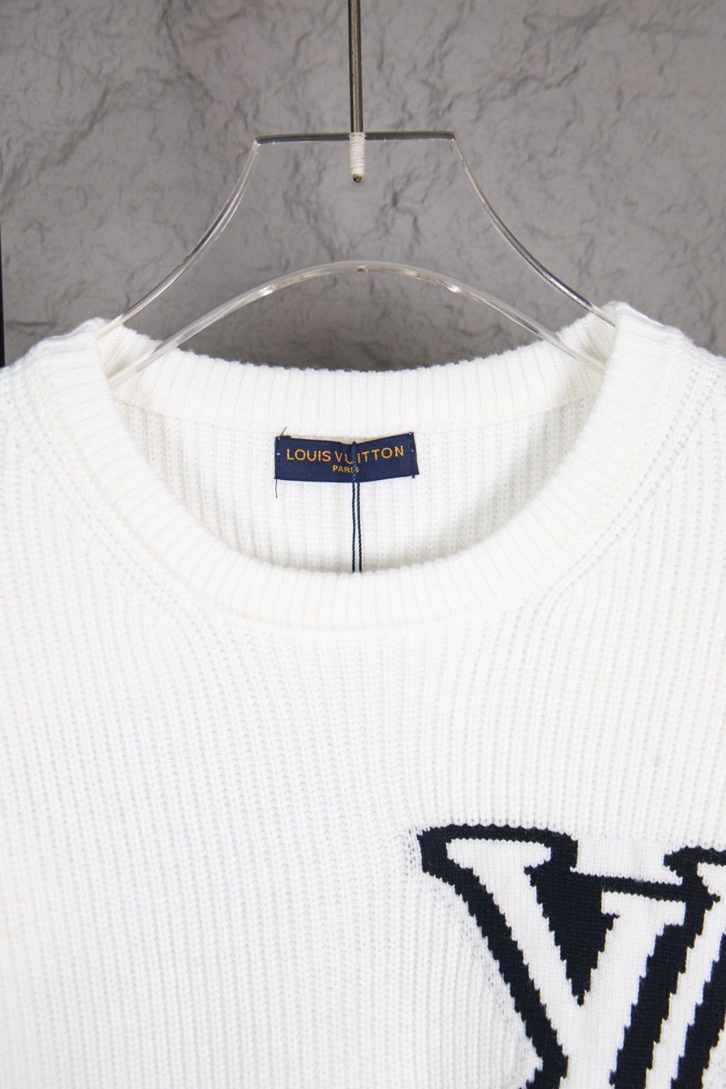 White ribbed knit sweater neckline with Louis Vuitton label