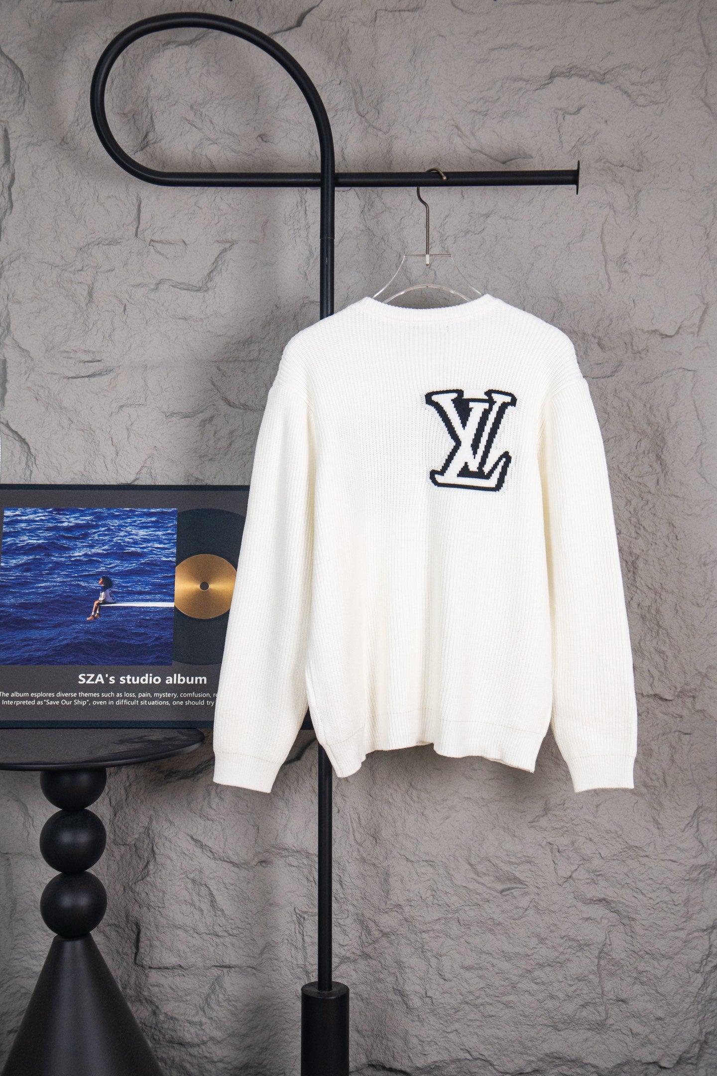 White long-sleeve knit sweater with navy LV logo on back