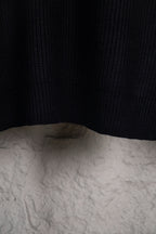 Dark navy knit sweater hem and back panel on hanger