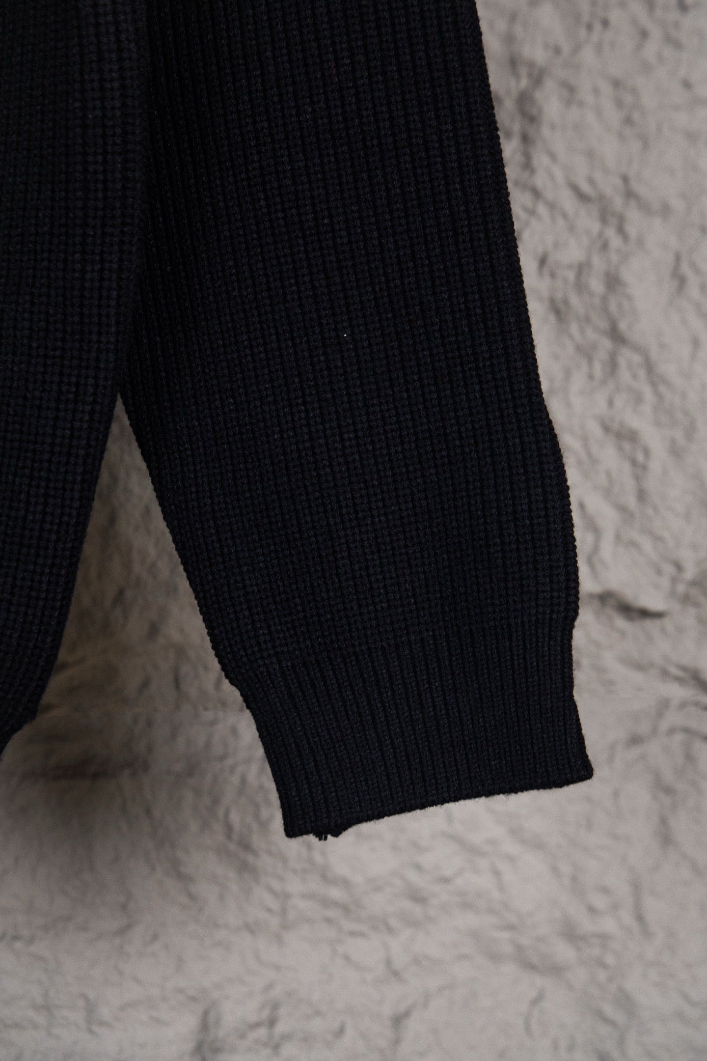Dark navy knit sweater sleeve with ribbed cuff