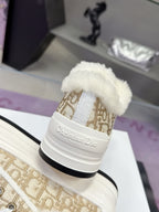 Heel view of white low-top sneaker with beige monogram band and plush collar lining