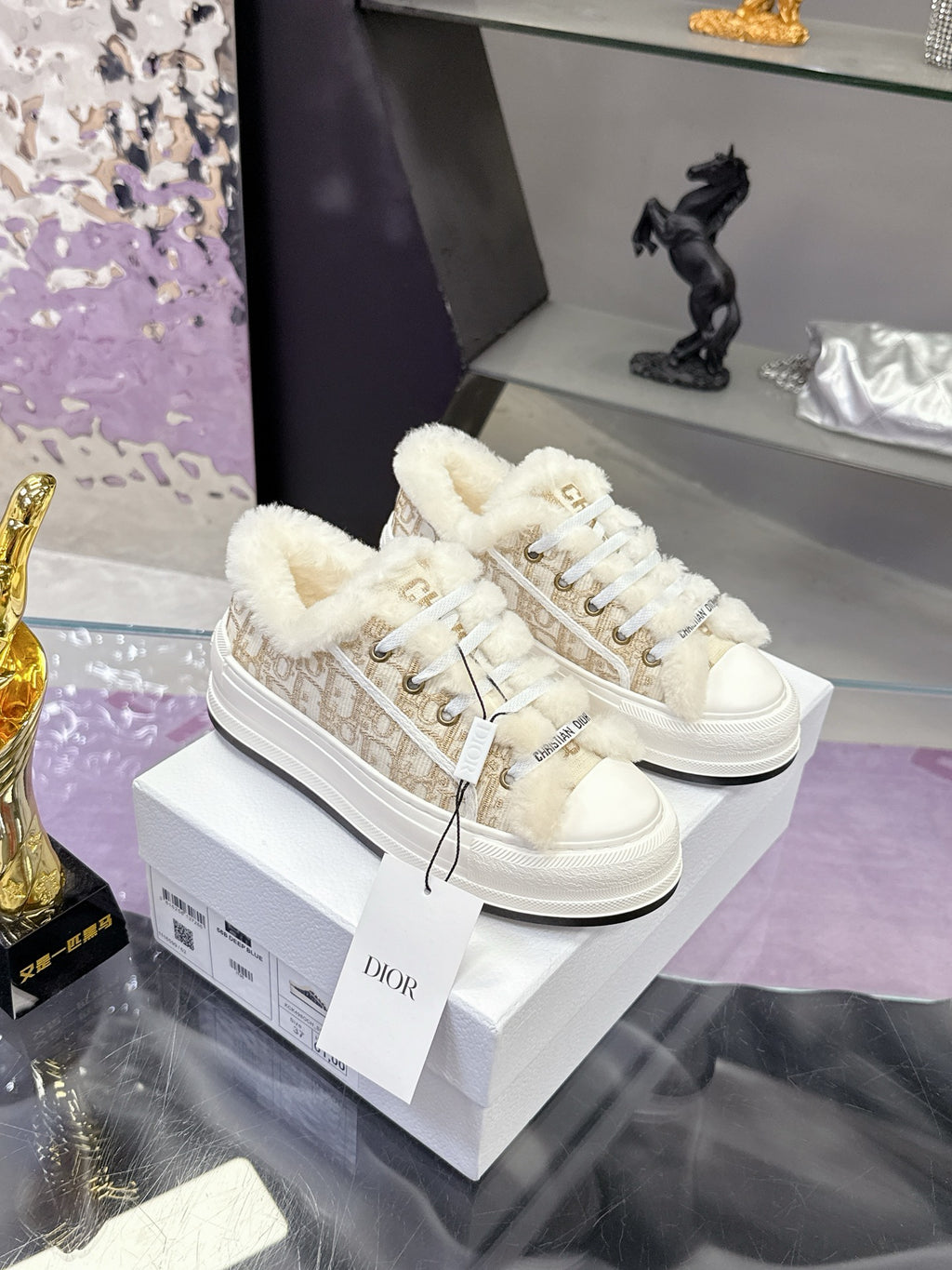 White low-top sneakers with faux fur lining and lace-up front; gold logo trim