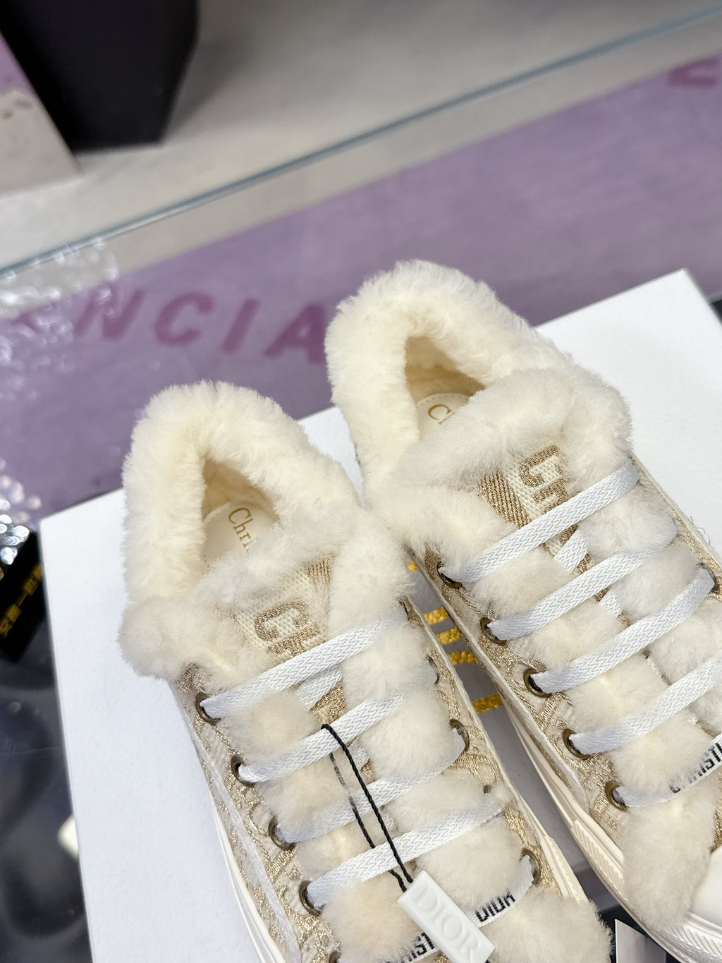 White sneakers with beige monogram fabric, plush lining, and lace-up front