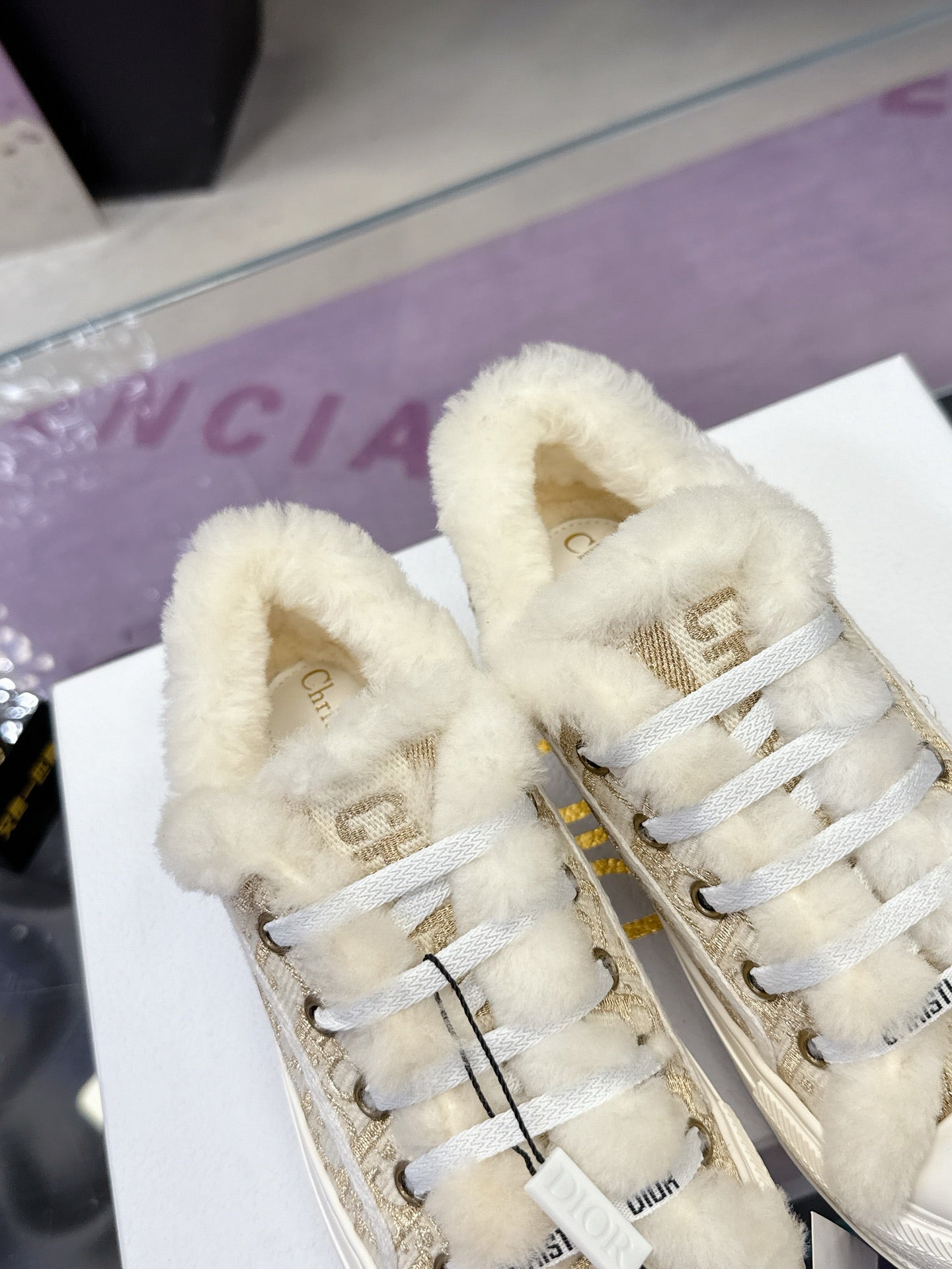 White sneakers with beige monogram fabric, plush lining, and lace-up front