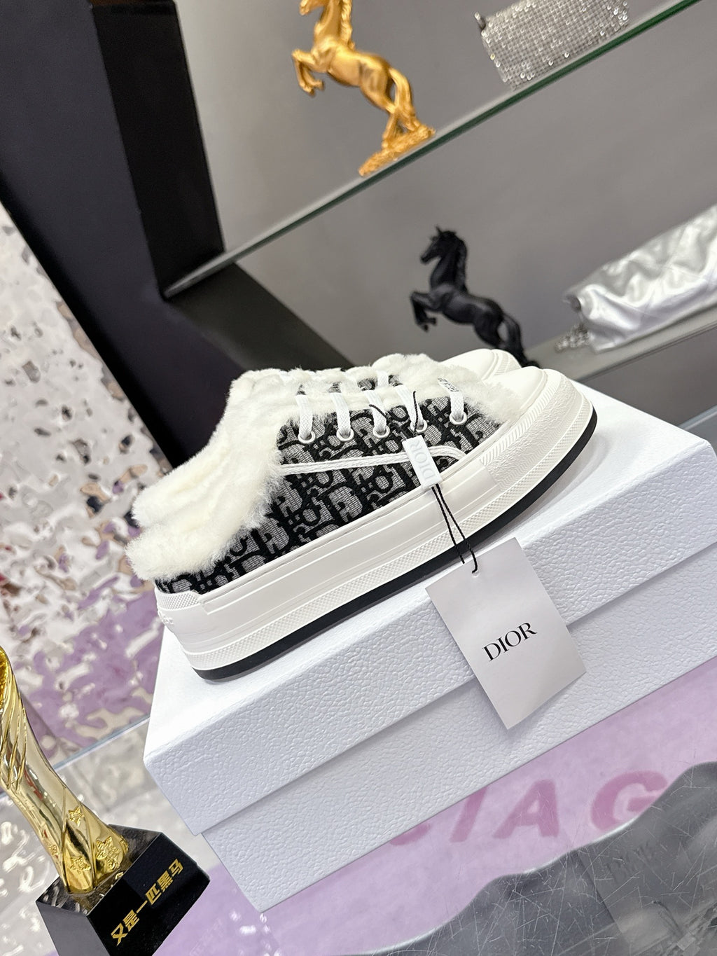 Low-top Dior sneakers with black logo-style textile, white laces, and faux-fur trim