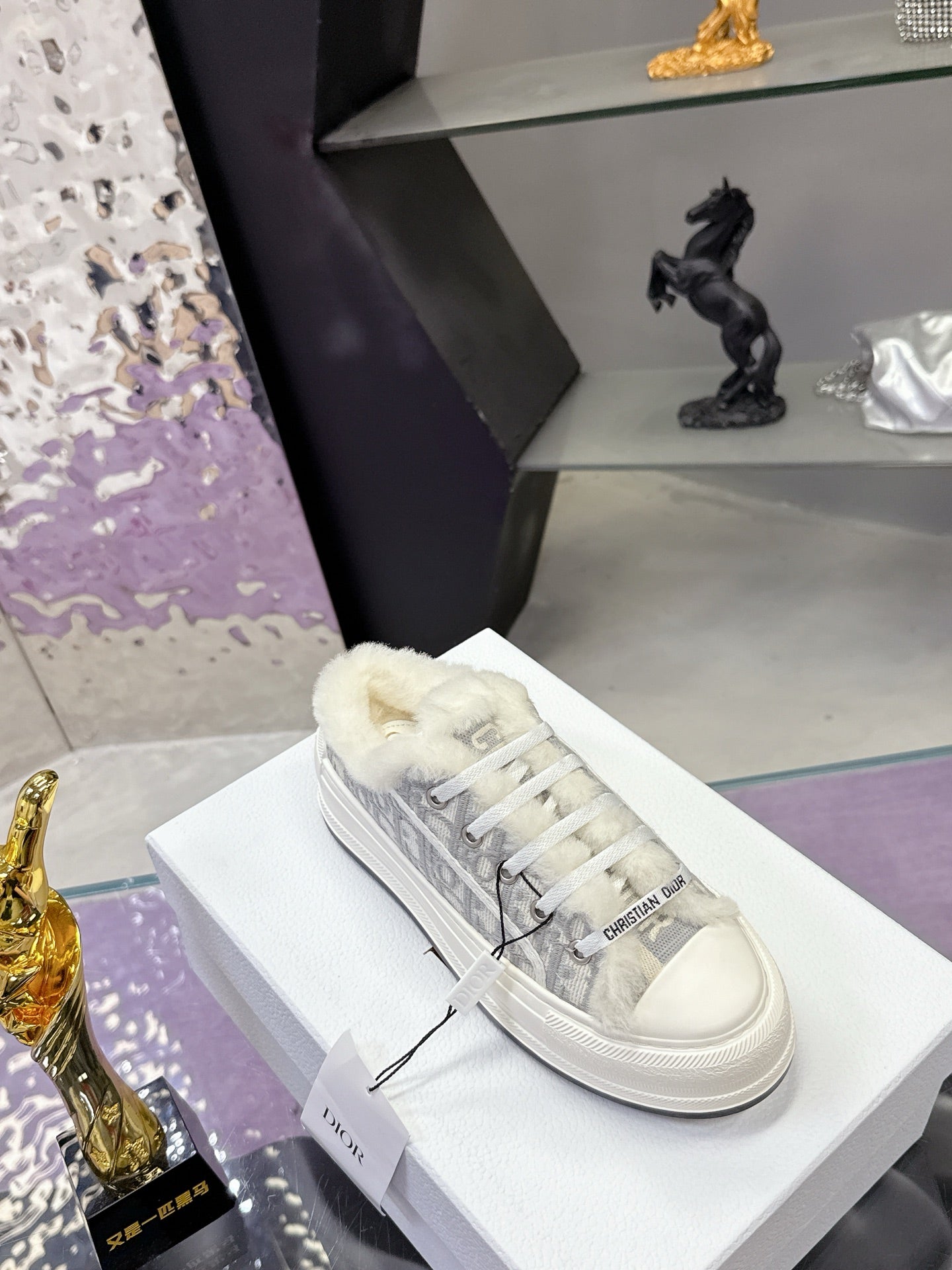 Dior women’s high-top sneakers, side view in white with gray monogram fabric and plush trim