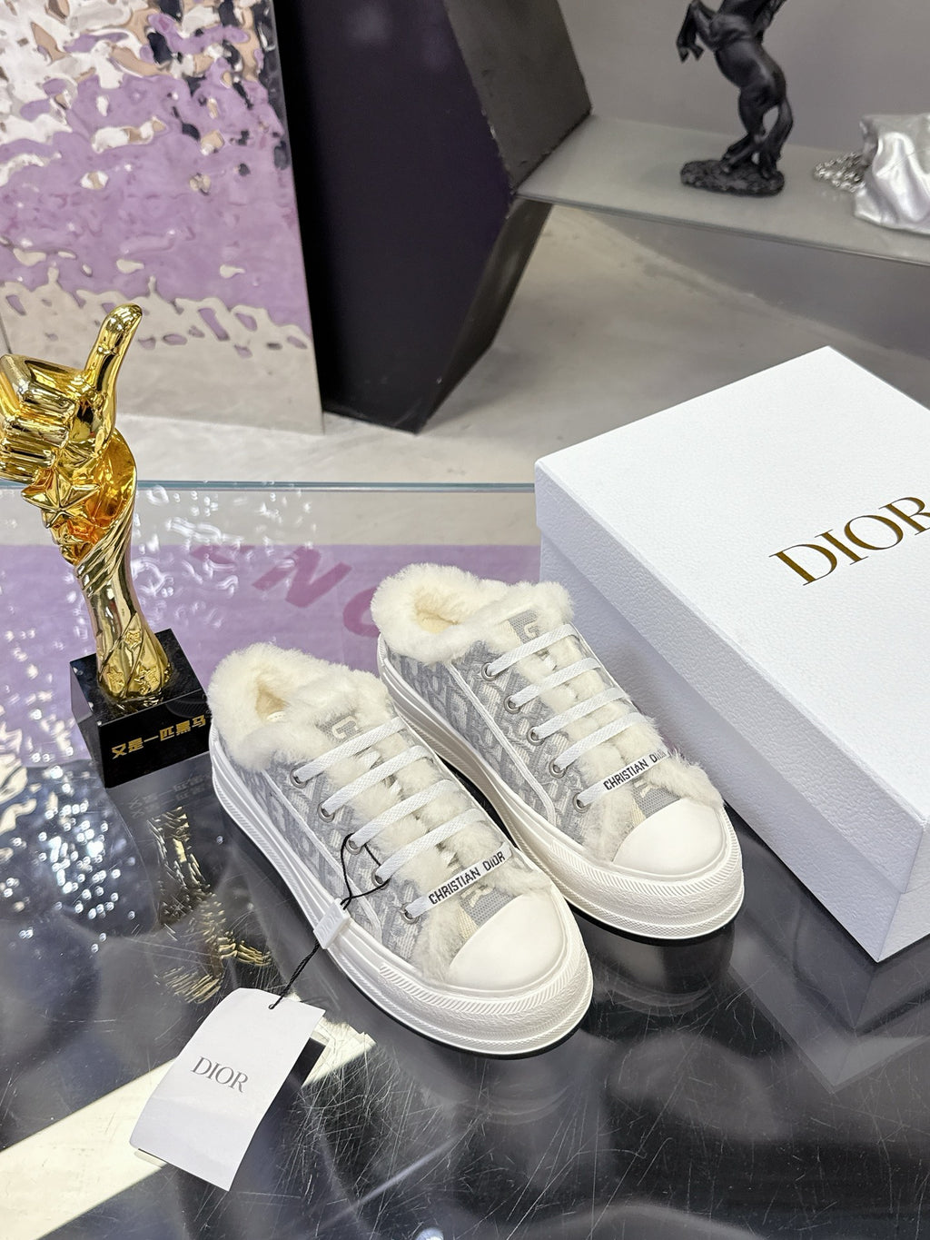 Dior women’s high-top sneakers on display, white soles with gray logo-print and fur collar