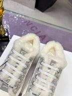Dior women’s high-top sneakers, front view showing gray logo uppers and white faux-fur lining