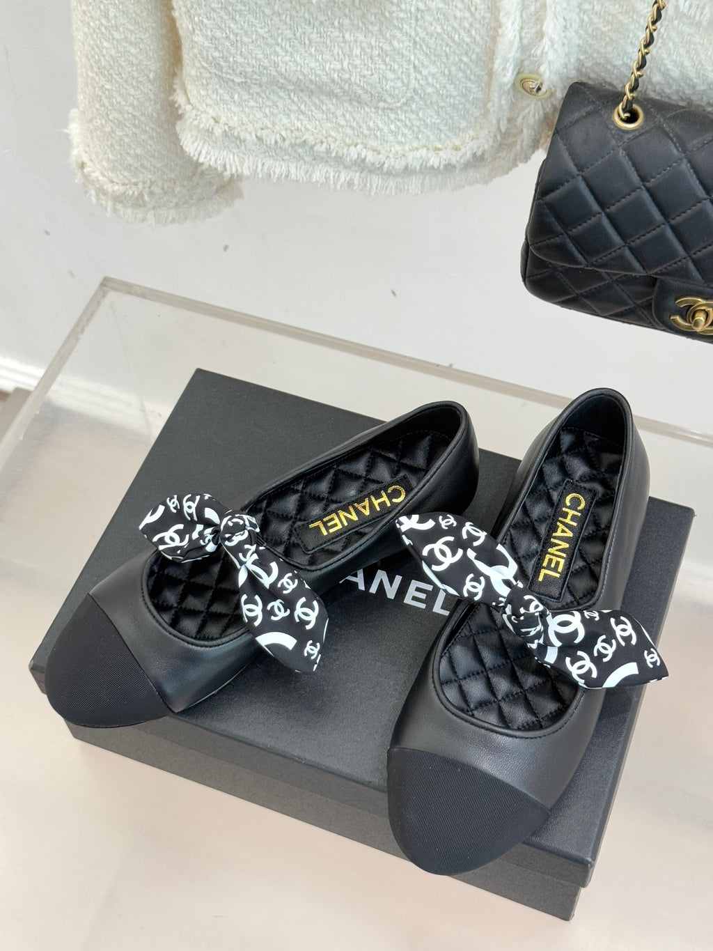 Black quilted loafers with white monogram bow and Chanel lettering insole