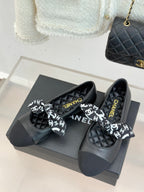 Black quilted loafers with white monogram bow and Chanel lettering insole