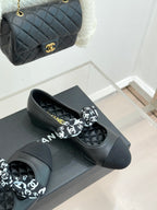 Black leather loafers with white monogram bow, side view on display box