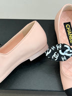 Blush pink ballet flat with Chanel logo label and black-and-white patterned bow