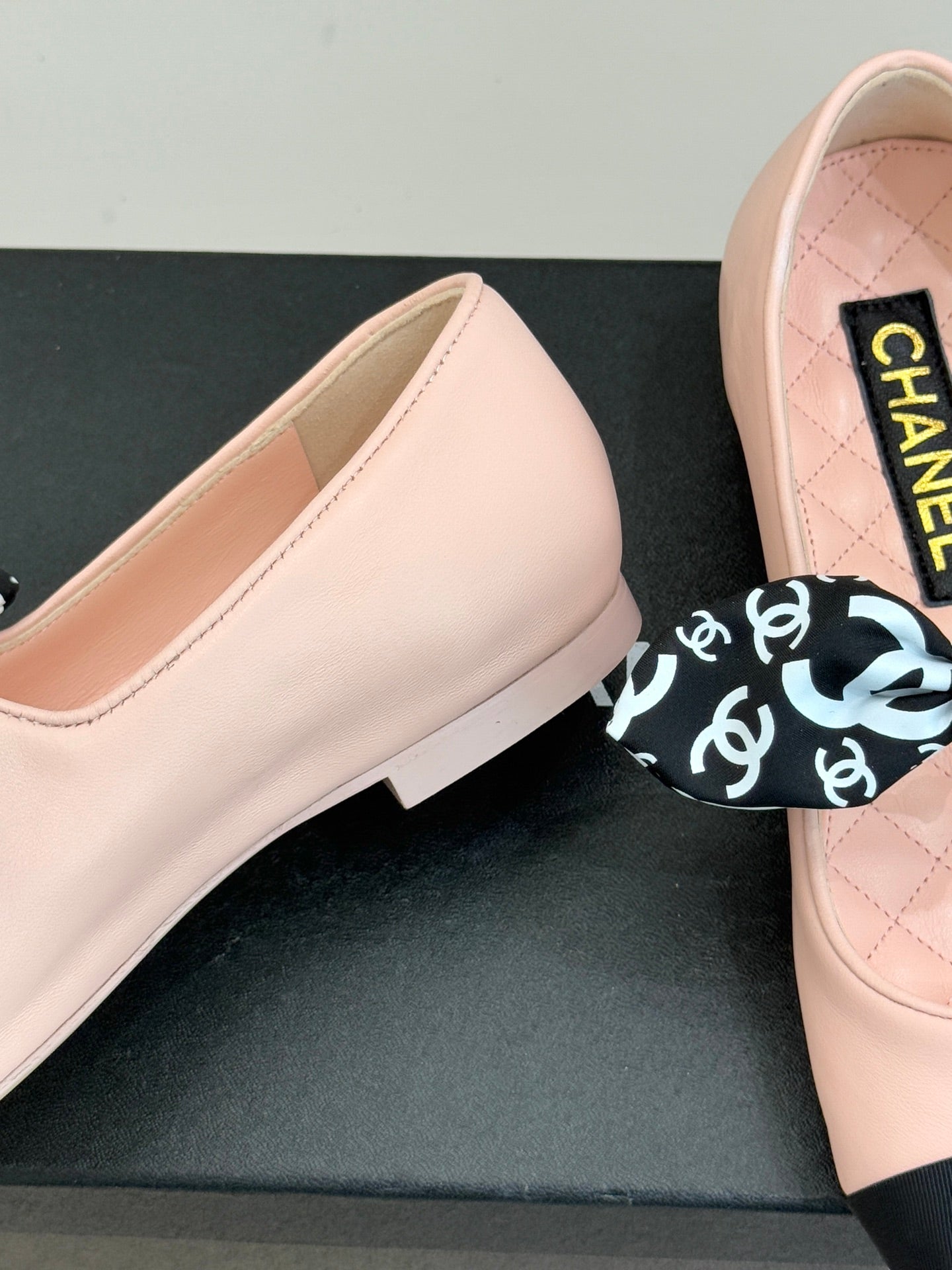 Blush pink ballet flat with Chanel logo label and black-and-white patterned bow