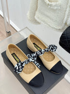 Beige and navy ballet flats with logo bow and CHANEL insoles, angled view