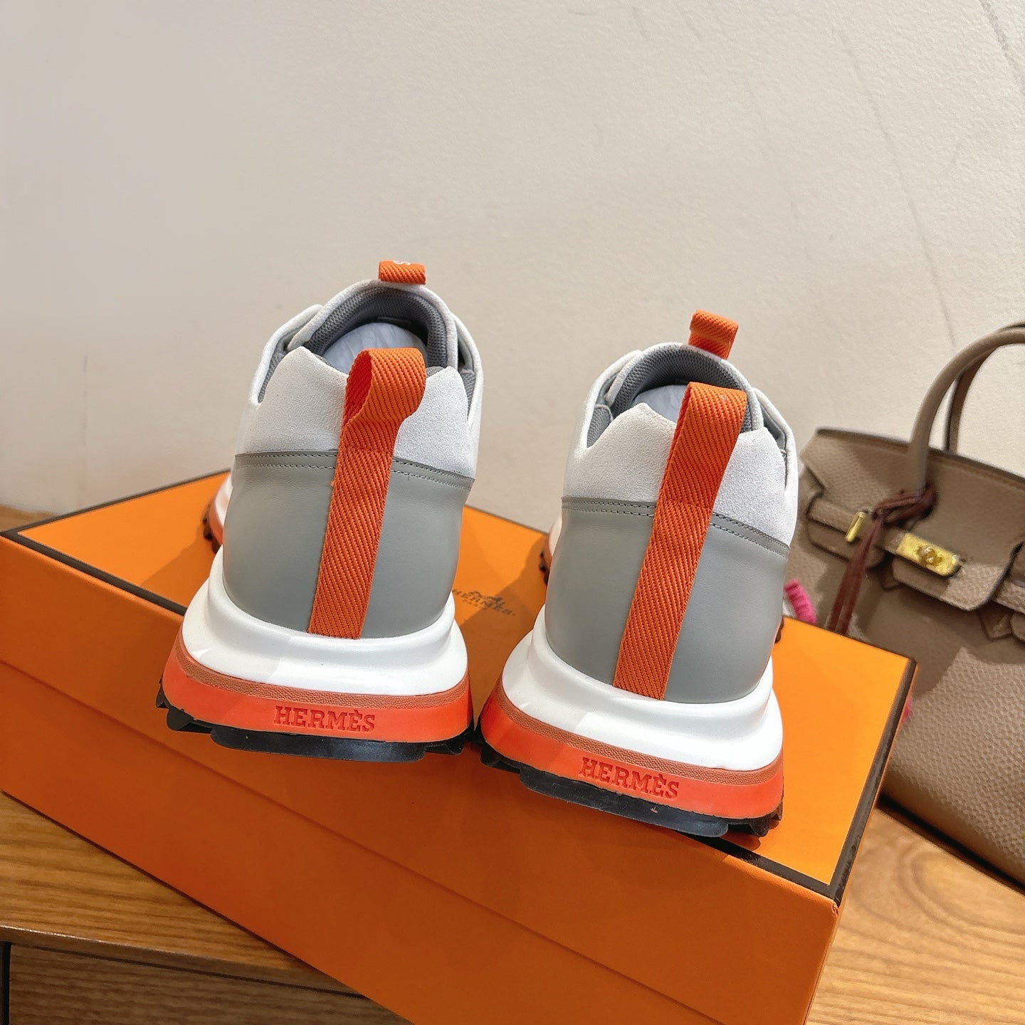 Hermes unisex sneakers, heel view with orange pull tab and orange outsole edge