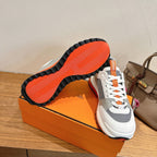 Hermes unisex sneakers, sole view with orange tread and white gray upper