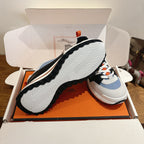 Unisex sneaker sole view in box: ridged tread with white, blue, black upper details