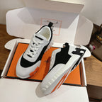Pair of white and black lace-up sneakers with orange trim, unisex luxury shoes