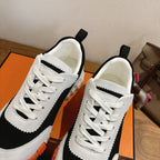 White and black lace-up sneakers with padded collar and orange sole trim