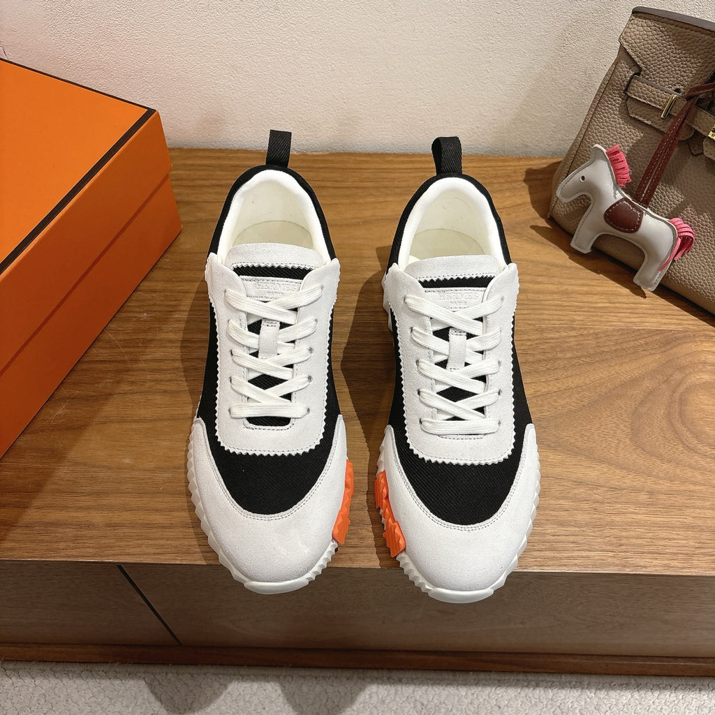 White and black lace-up sneakers with orange accents, unisex luxury shoes