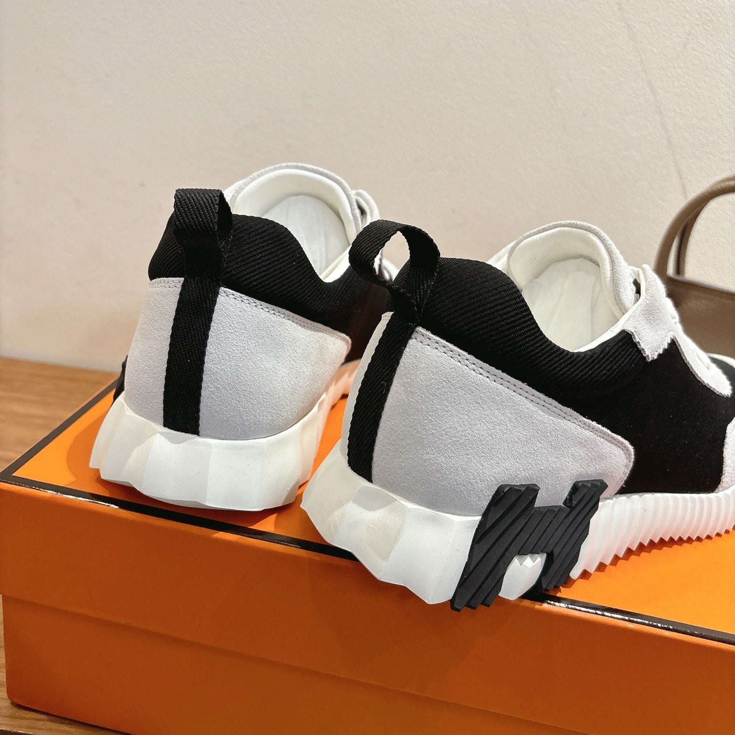 White and black sneakers with padded back and orange sole edge, unisex luxury shoes