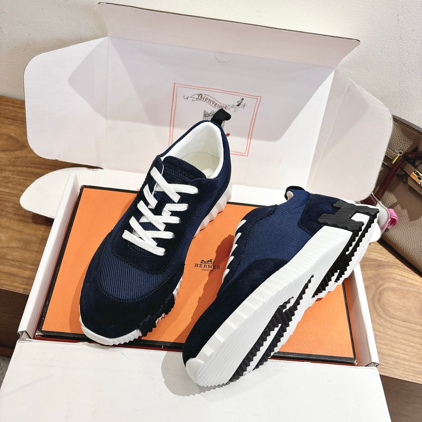 Hermes unisex sneakers with navy upper, white laces, and chunky white outsole