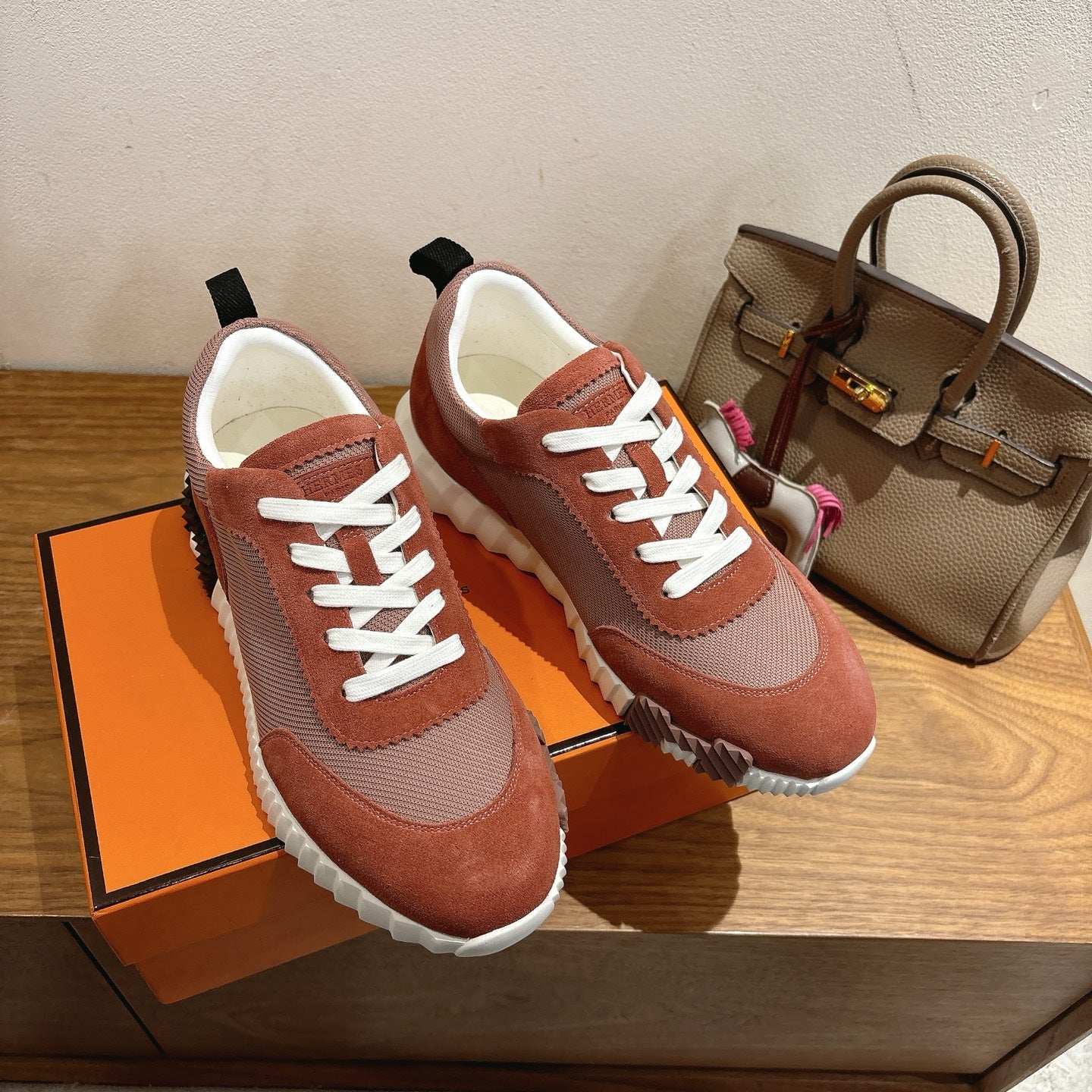 Unisex Hermes sneakers close-up, rust-brown and gray mesh with white laces, textured sole
