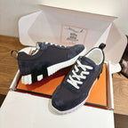 Unisex sneakers, dark upper with white laces, ridged white sole and padded collar
