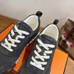 Unisex sneaker close-up: dark upper, white lace-up front, white rubber sole edge
