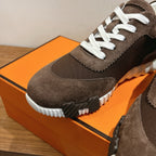 Hermes unisex sneakers, dark brown suede, close-up of white sole tread and lace panel