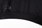Black long-sleeve hoodie ribbed hem with small stitched logo patch