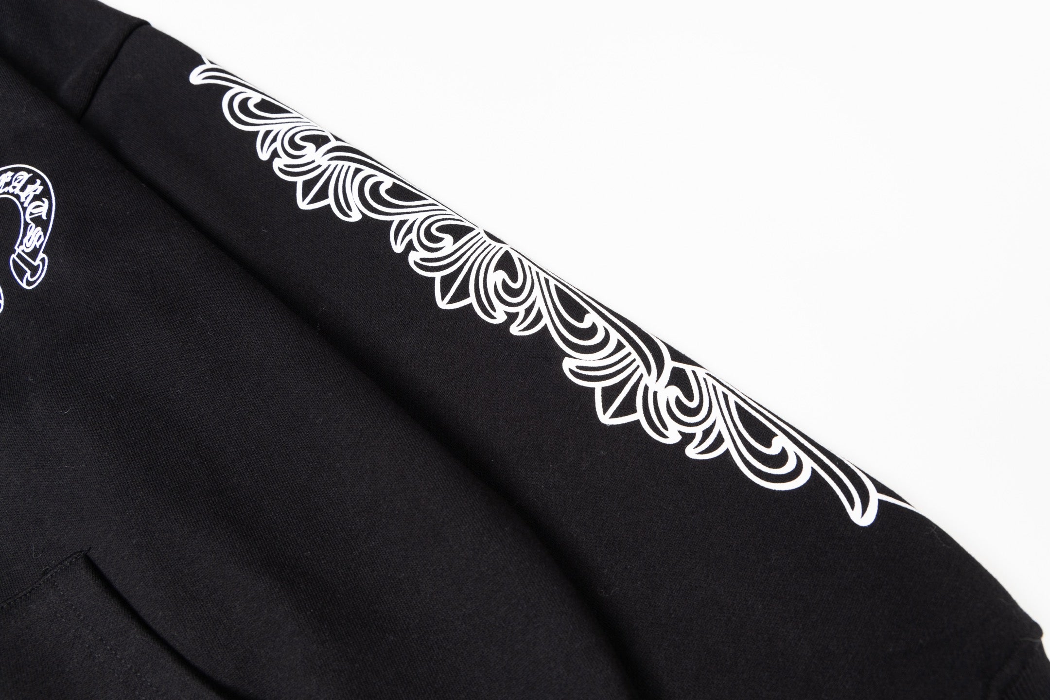 Black long-sleeve hoodie sleeve with white ornamental graphic