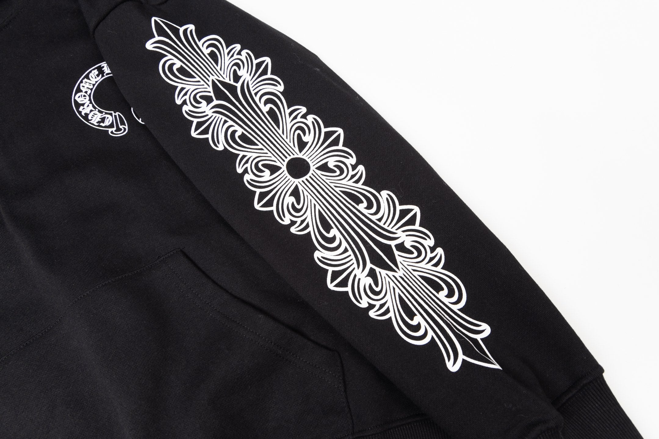 Black hoodie sleeve graphic close-up with ornate floral design