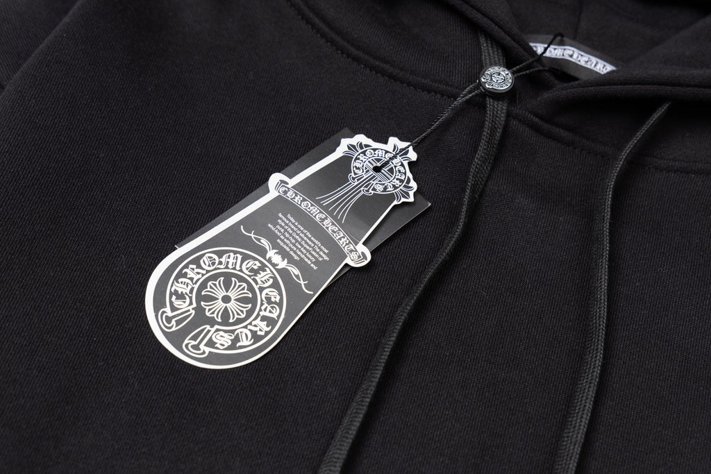 Black hoodie fabric close-up with woven neck label and drawstring top