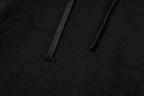 Black hoodie close-up showing kangaroo pocket opening and stitched hem