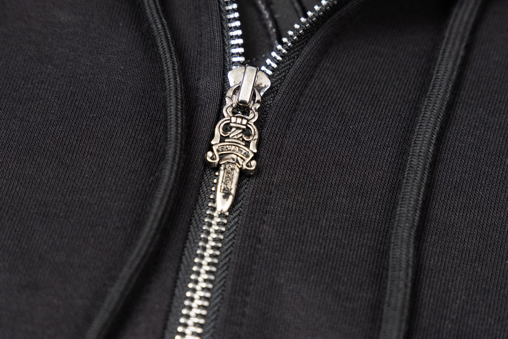 Silver zipper pull and teeth on black zip-up hoodie