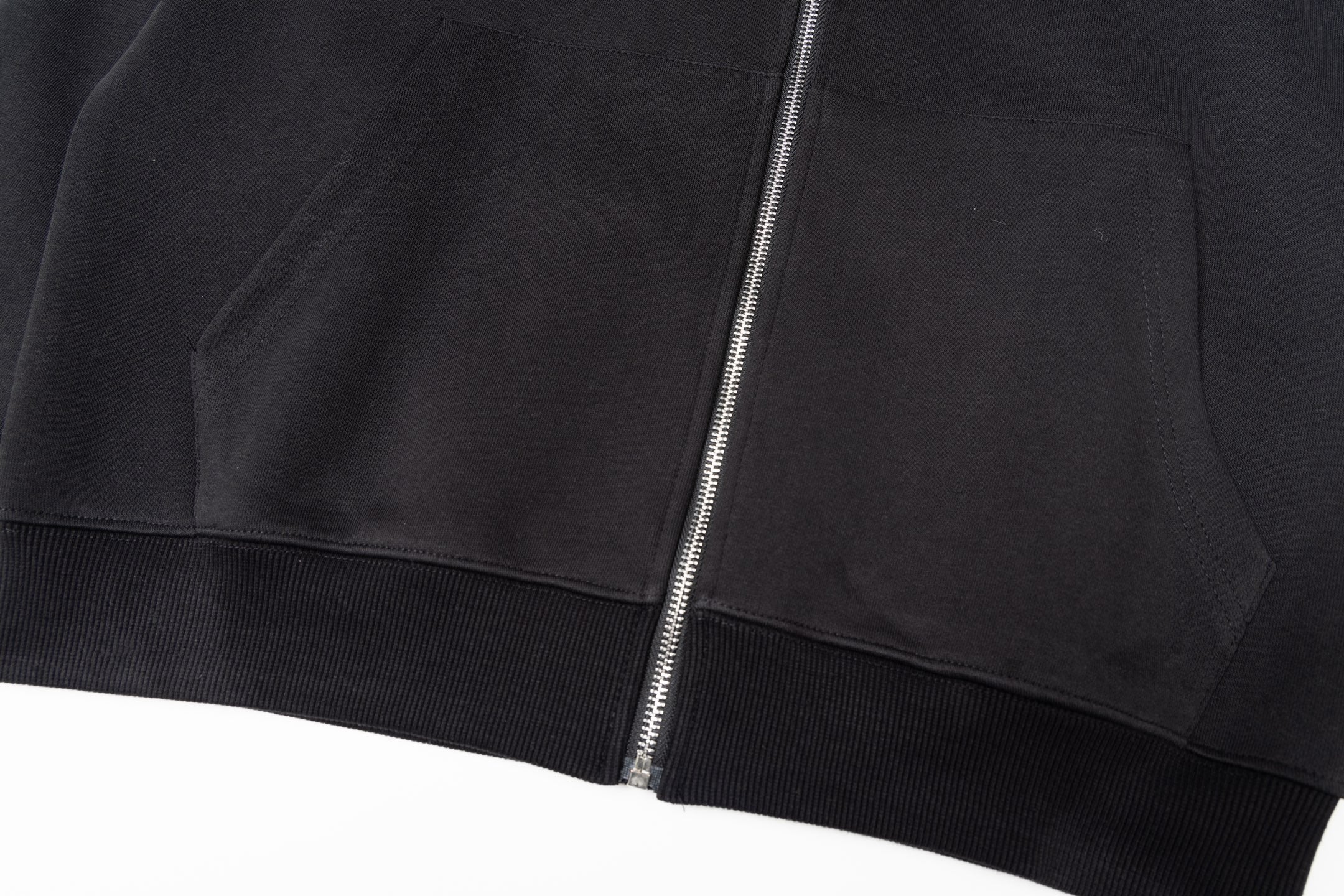 Black zip-up jacket with central zipper and ribbed hem