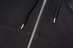 Black hoodie front close-up showing two drawstring tips and zipper seam