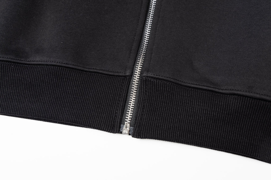 Black jacket hem with ribbed cuffs and metal zipper pull