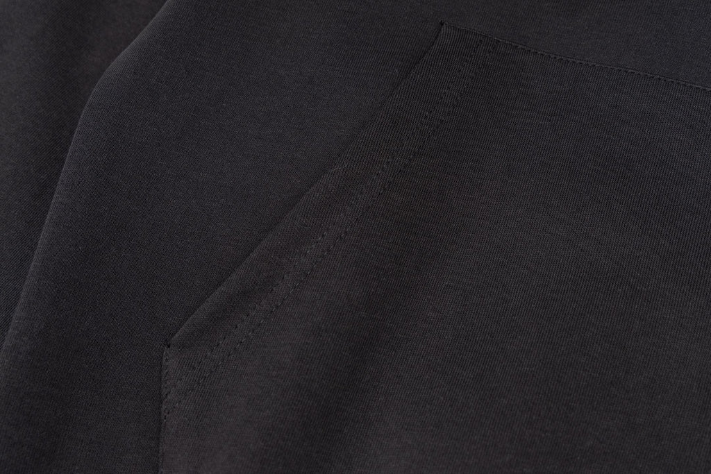 Black jacket fabric with subtle texture and stitched seam line