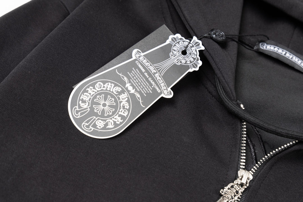 Black hoodie close-up with hanging brand tag near the zipper and pocket