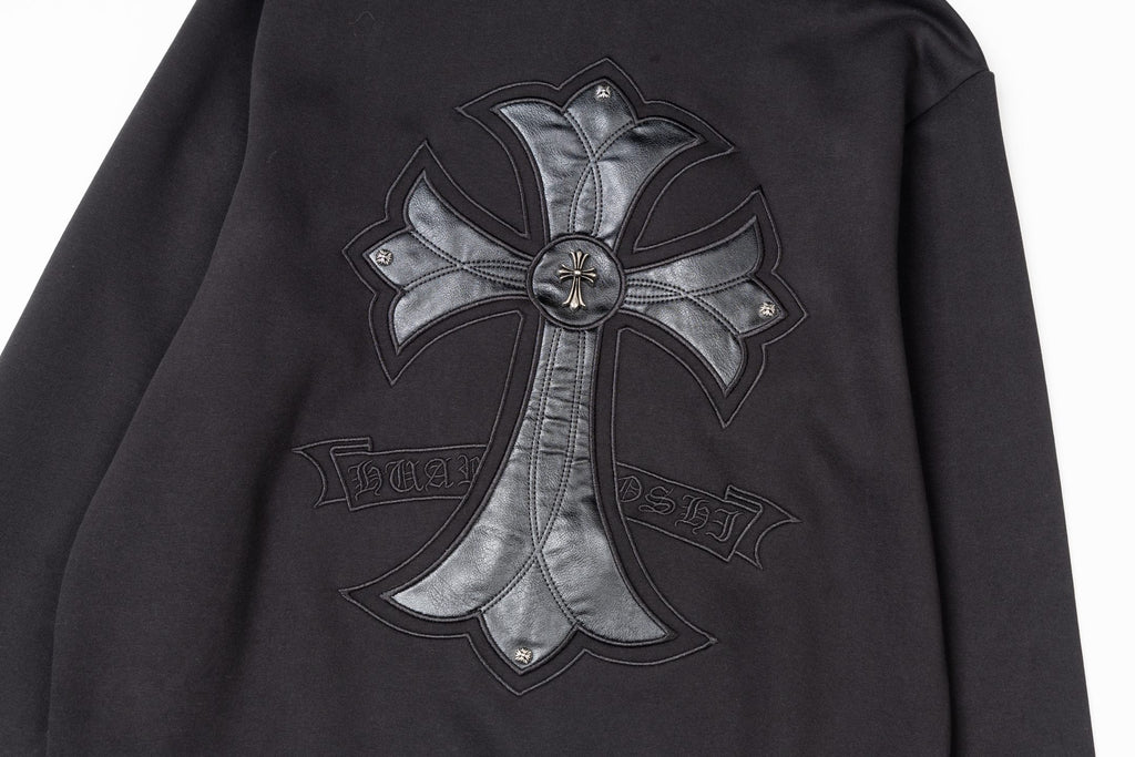 Black zip-up jacket with chrome-style cross emblem and stitched detailing