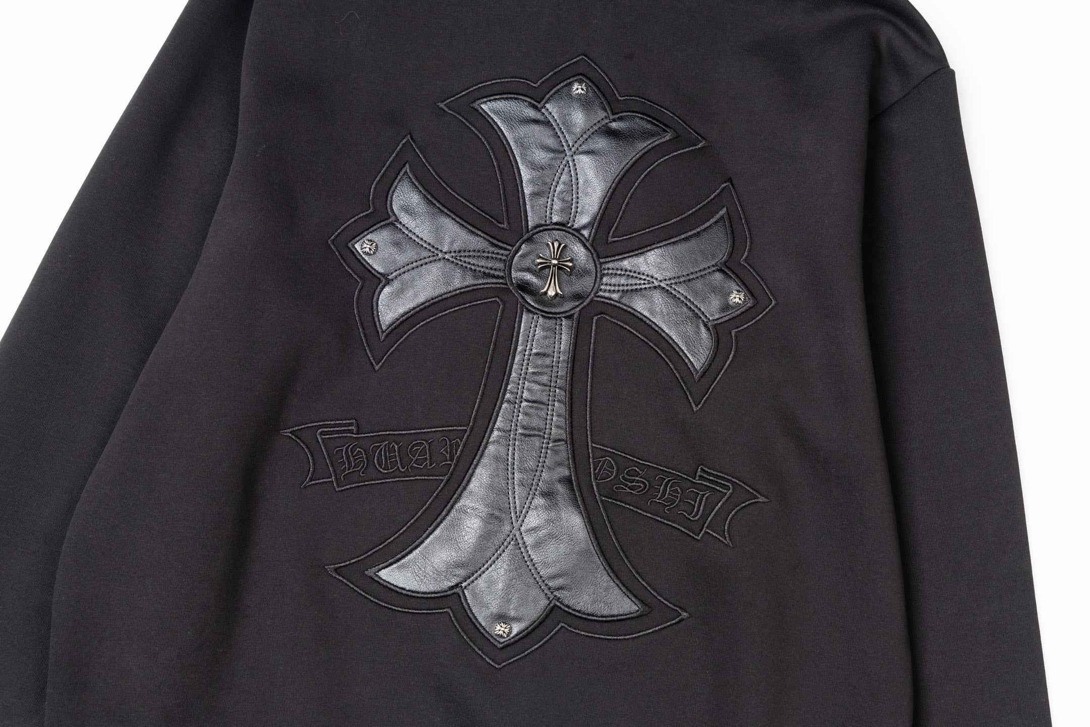 Black zip-up jacket with chrome-style cross emblem and stitched detailing