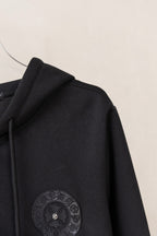 Black zip-up hoodie side view with circular sleeve emblem