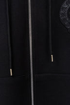 Black zip-up hoodie close-up of metal zipper and hood drawstring tips