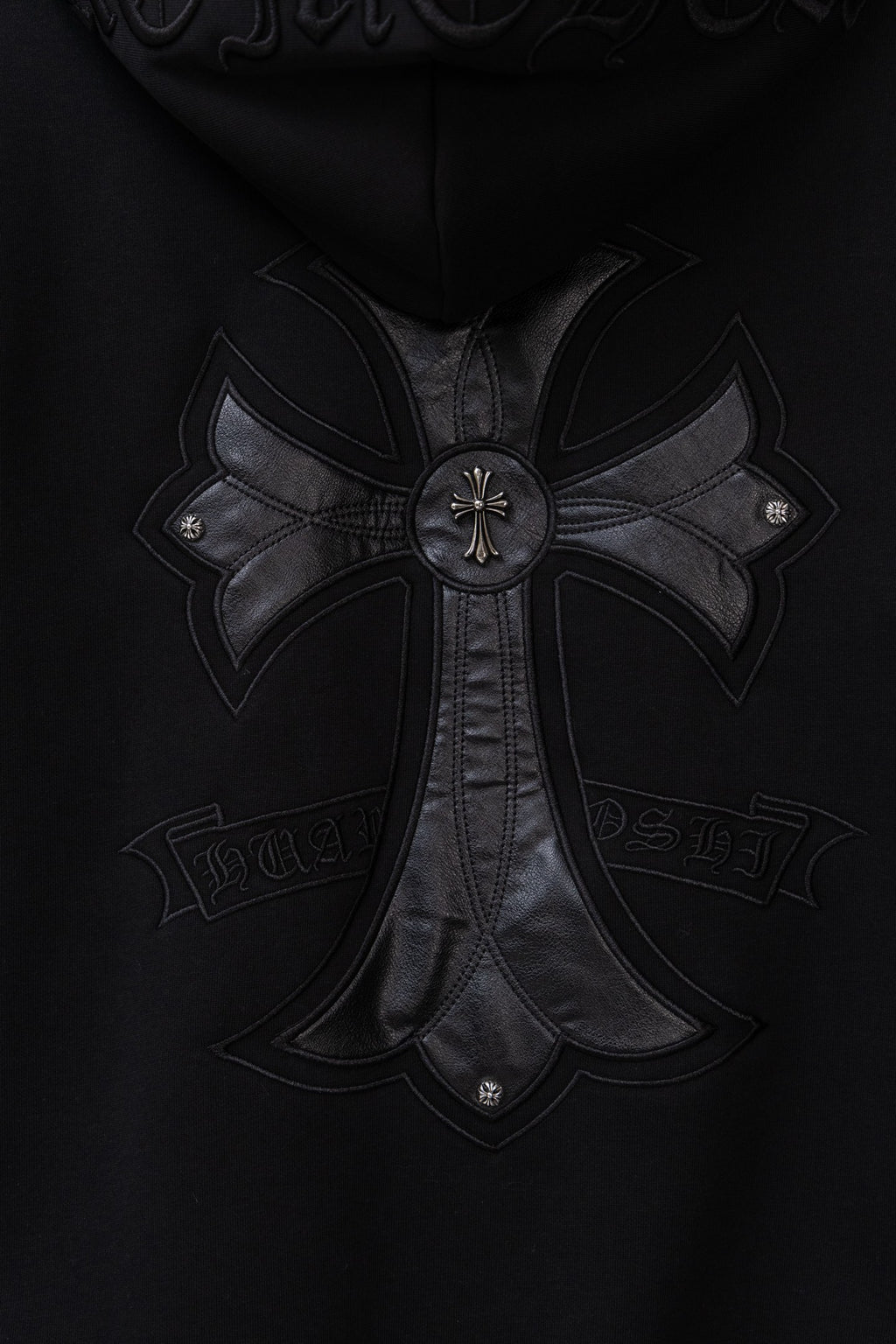 Black zip hoodie with large embroidered cross logo at the chest