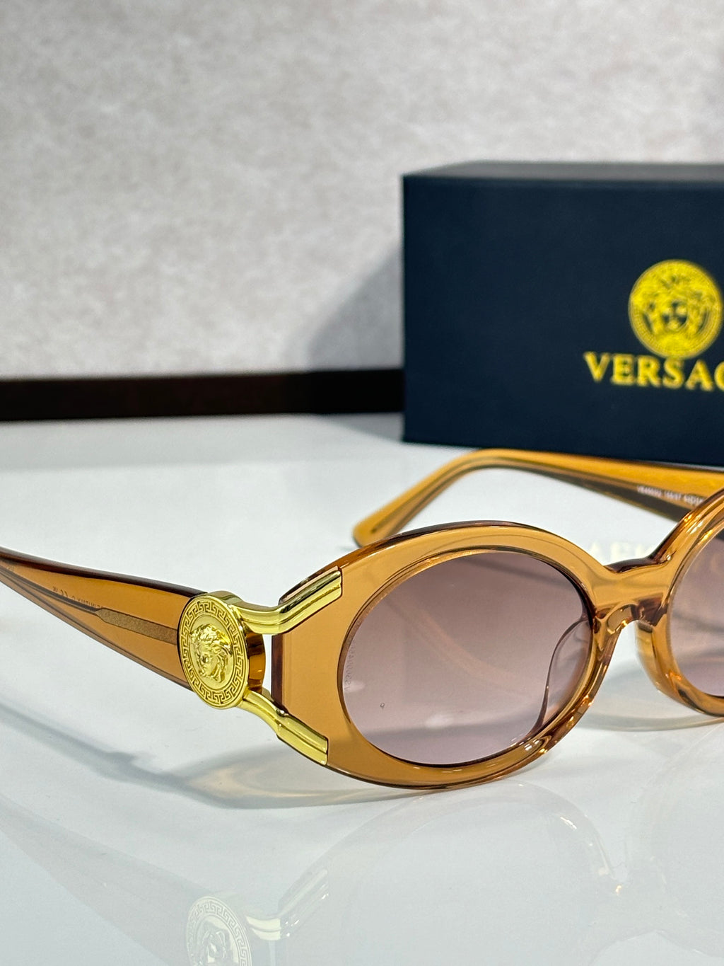 Sunglasses close-up with gold round frames and pink-tinted lenses