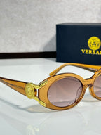 Sunglasses close-up with gold round frames and pink-tinted lenses